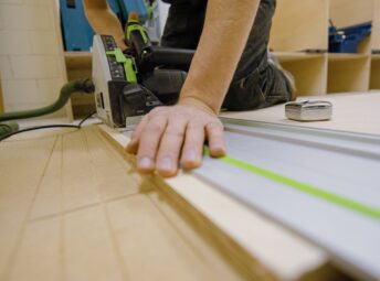 person in gray t-shirt holding green and white plastic tool