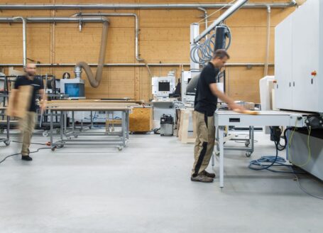 woman in black shirt and gray pants standing near white table